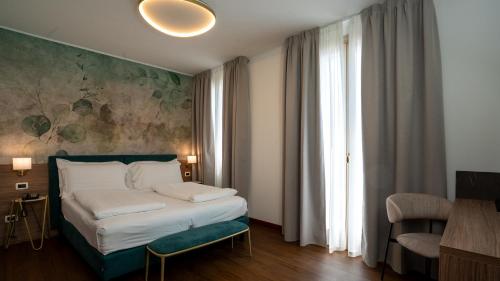a bedroom with a bed and a large window at Gardone Palace Hotel in Gardone Riviera
