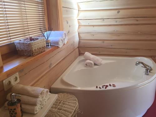 ein Badezimmer mit einer weißen Badewanne und einem Waschbecken in der Unterkunft Eco-House Ainaži in Ainaži