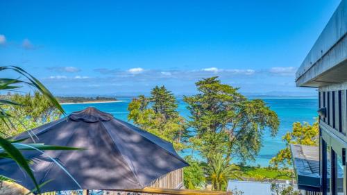 an umbrella sitting on a patio overlooking the ocean at Rangi Terrace Views in Karikari Peninsula