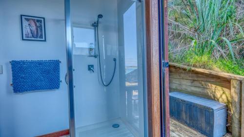a shower in a bathroom with a glass door at Rangi Terrace Views in Karikari Peninsula