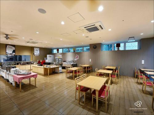 a restaurant with tables and chairs and a kitchen at Daiwa Roynet Hotel Numazu in Numazu
