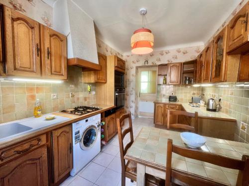 une cuisine avec des armoires en bois et une laveuse et une sécheuse dans l'établissement Belle-epoque apartment ,3bedrooms with sea view, à Cannes