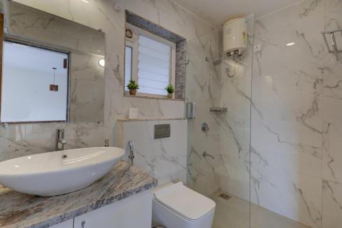a white bathroom with a sink and a toilet at Casa Avasa - 3bhk Private Pool Villa in Siolim in Camorlim