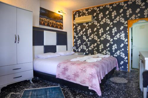 a bedroom with a bed with towels on it at İMREN'S OTEL in Cesme