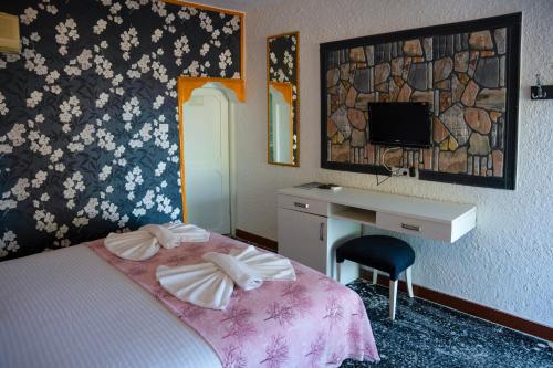 a hotel room with a bed and a desk and a mirror at İMREN'S OTEL in Cesme