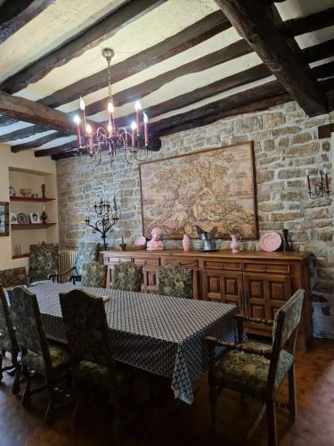 une salle à manger avec une table et des chaises et un mur en pierre dans l'établissement Le relais de campagne à 5 min de Padirac, à Miers
