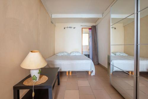 een slaapkamer met twee bedden en een tafel met een lamp bij Jeux de boules 1 - T2 in Le Pradet