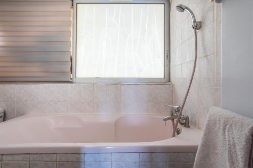 een badkuip in een badkamer met een raam bij Jeux de boules 1 - T2 in Le Pradet