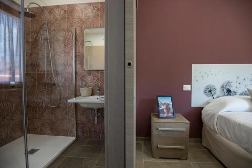 a bathroom with a shower and a bed and a sink at Da MammaMimma in Cascia