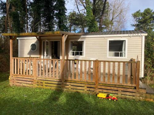 une petite maison avec une clôture en bois dans l'herbe dans l'établissement La petite maison - Camiers, à Camiers