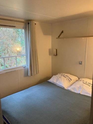 une petite chambre avec deux lits et une fenêtre dans l'établissement La petite maison - Camiers, à Camiers