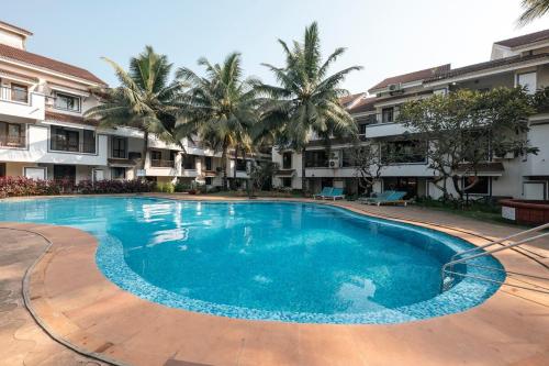 a large swimming pool in a courtyard with palm trees at El Fureidis by Satiwa stays in Arpora