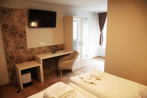 a room with two beds and a desk with a computer at Pension Villa Colosseo im Herzen von Meiningen in Meiningen