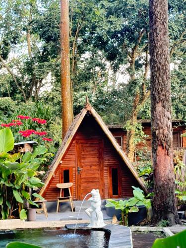 a small house with a statue in front of it at Triangle House and hot spring in Kintamani