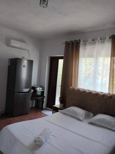 a bedroom with a white bed and a television at Tonia&Sion in Vlorë