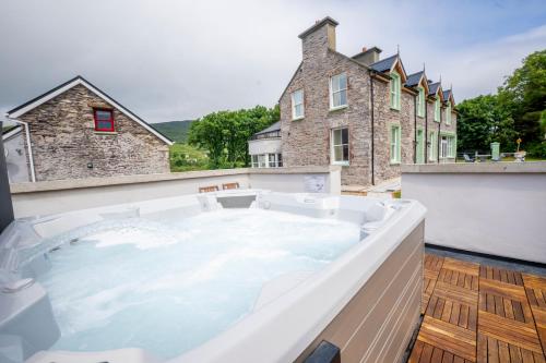a hot tub on the balcony of a house at Tobervilla Guest House in Caherdaniel