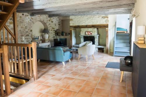 a living room with a blue couch and a fireplace at Maison de charme Portobelo dans Carennac avec vue in Carennac