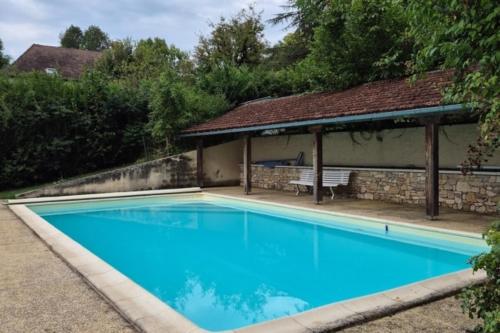 - une piscine en face d'une maison avec un kiosque dans l'établissement Ma maison de famille en Quercy avec piscine, à Floirac