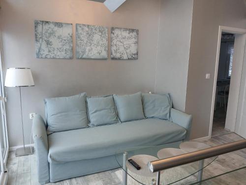 a blue couch in a living room with two pictures on the wall at Pensjonat Magdalena in Szklarska Poręba
