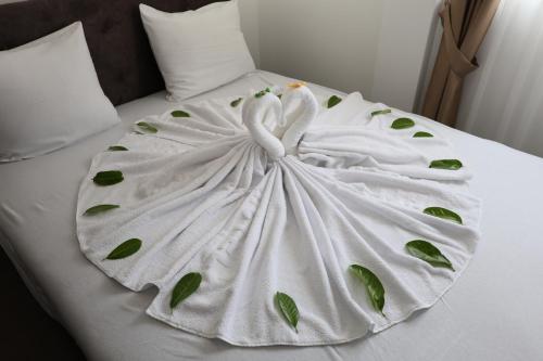 a white blanket with leaves on a bed at Hotel Lobo Budva in Budva