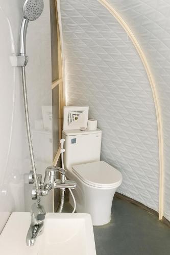 a bathroom with a white toilet and a shower at Vietnam Surf Camp in Ấp Mỹ Hải