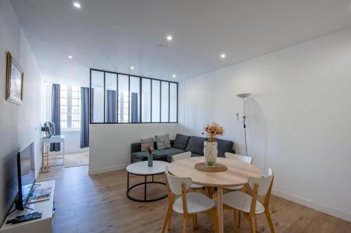 un salon avec une table et un canapé dans l'établissement Chic & Moderne 3 min Vieux-Port & Panier 4P, à Marseille