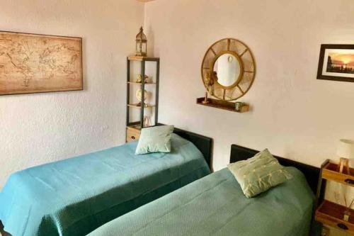 - 2 lits dans une pièce avec miroir dans l'établissement Au calme entre les pins a 300m de la plage, à Argelès-sur-Mer