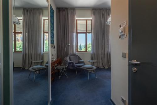 a waiting room with chairs and a table and windows at Kabadoni Boutique Hotel in Sighnaghi