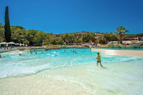 un groupe de personnes dans l'eau d'une piscine dans l'établissement Villa Les Chênes Les Restanques du Golfe de St Tropez, à Grimaud
