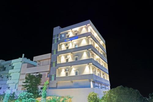 a tall building with its lights on at night at FabHotel Dharani Grand - Nr Mamata Medical College in Khammam