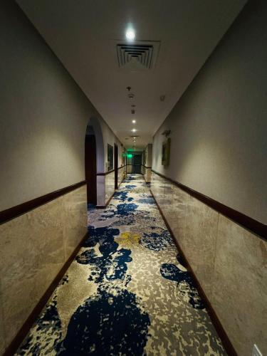 a hallway with a tile floor in a building at Elite Park Hotel in Jeddah