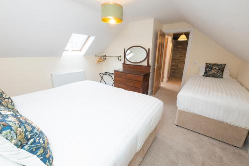 a attic bedroom with two beds and a mirror at Tobervilla Guest House in Caherdaniel