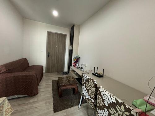 a living room with a couch and a table at Nich Mono Ramkhumheng Low Rise in Sathani Ban Hua Mak
