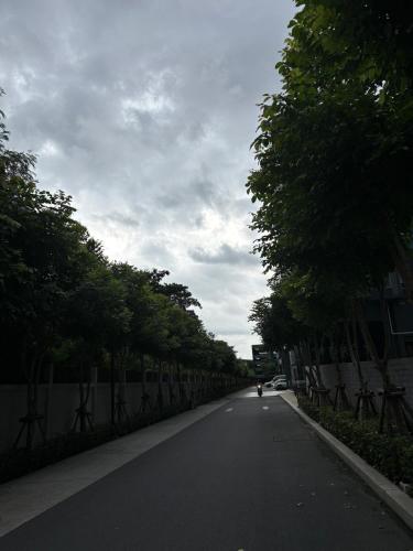 a street with trees and a person riding aooter on the road at Nich Mono Ramkhumheng Low Rise in Sathani Ban Hua Mak