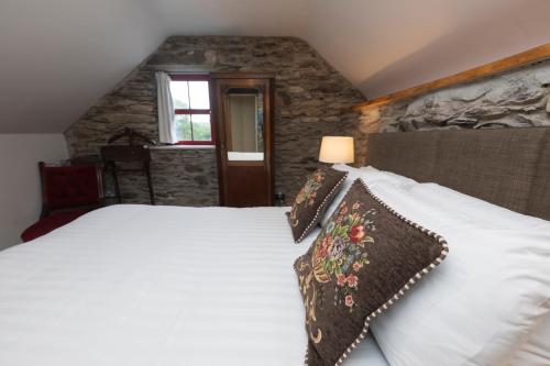 a bedroom with a bed with white sheets and a window at Tobervilla Guest House in Caherdaniel