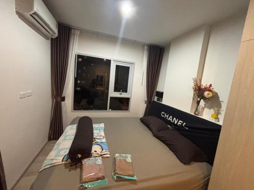 a girl laying on a bed in a small room at Nich Mono Ramkhumheng Low Rise in Sathani Ban Hua Mak