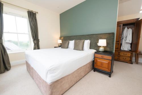 a bedroom with a large white bed and a window at Tobervilla Guest House in Caherdaniel