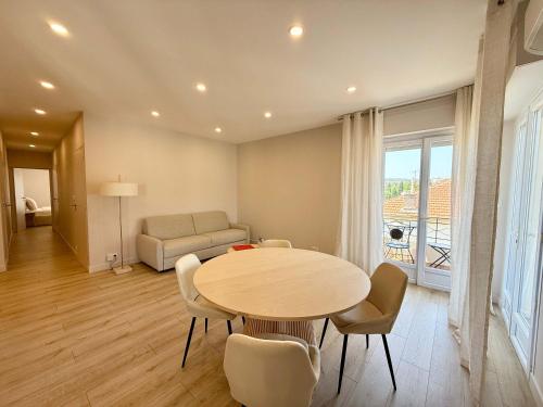 un salon avec une table, des chaises et un canapé dans l'établissement B058 Superbe appartement 2 chambres garage prive, à Cannes