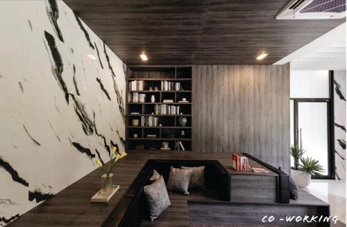 a living room with a couch and a book shelf at Nich Mono Ramkhumheng Low Rise in Sathani Ban Hua Mak