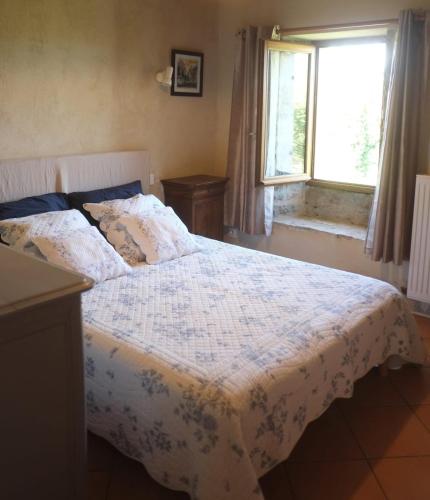 - une chambre avec un lit doté d'une couverture blanche et d'une fenêtre dans l'établissement La Sagnarde Loubressac Terrasse intime, à Loubressac