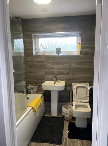 a bathroom with a sink and a tub and a toilet at Beautiful holiday home South Beach Blyth 3 minute walk to the beach in Newsham