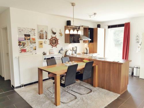 a kitchen with a wooden table and black chairs at Ferienwohnung Granata 52 0S in Schillig