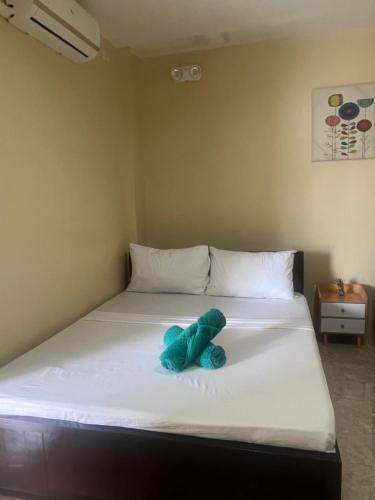 a blue stuffed animal sitting on a bed at Seamed Guest House - Family Room A in Pooc