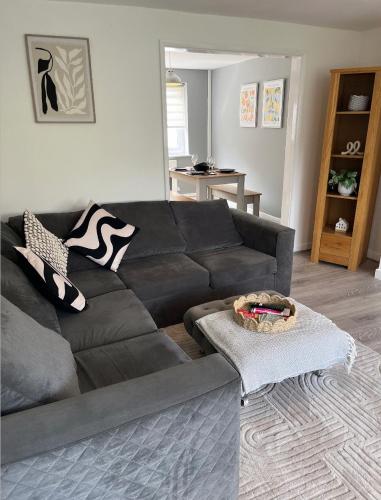 a living room with a black couch and a table at Beautiful holiday home South Beach Blyth 3 minute walk to the beach in Newsham