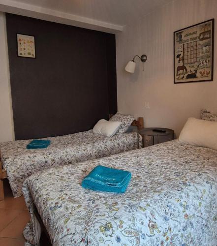 - 2 lits dans une chambre d'hôtel avec des serviettes bleues dans l'établissement La Sagnarde Loubressac Terrasse intime, à Loubressac