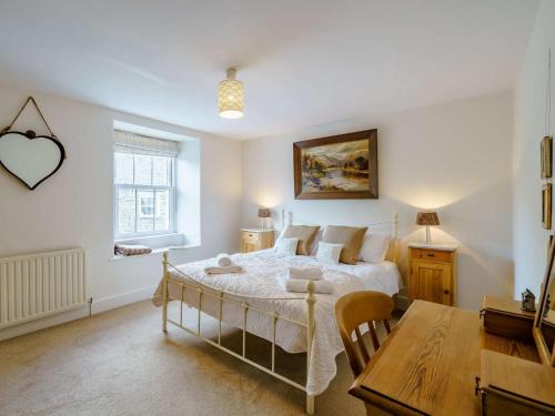 Un dormitorio con una cama, una mesa y un escritorio. en 4 Bed in Sawrey LCC33, en Near Sawrey