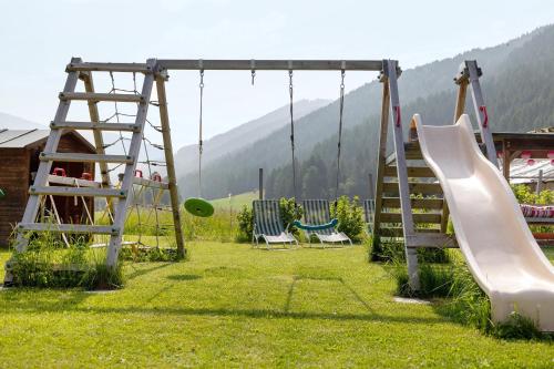 a playground with two swings and a slide at Untersinnerhof Gsies in Valle Di Casies