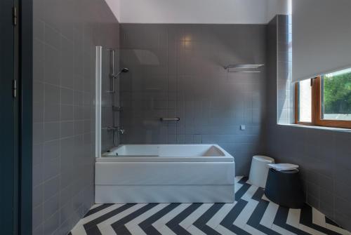 a bathroom with a white tub and a shower at Kabadoni Boutique Hotel in Sighnaghi