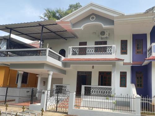 a large white house with a balcony at Backpack Travellers Hostel 500 per person -NonAC- 750 per person-AC in Colva