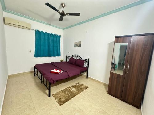 a bedroom with a bed and a ceiling fan at Backpack Travellers Hostel 500 per person -NonAC- 750 per person-AC in Colva